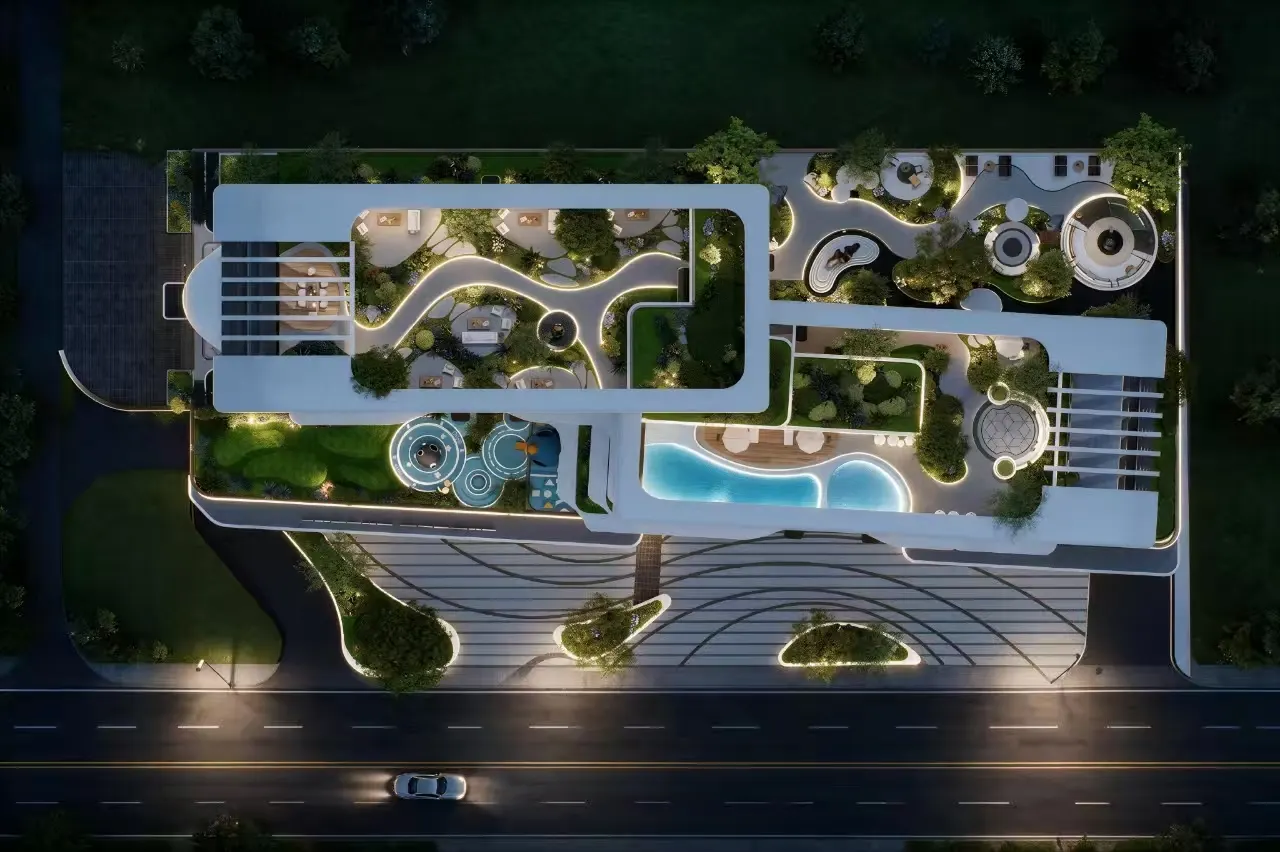 Night aerial of the landscaped podium, pools, and garden paths.