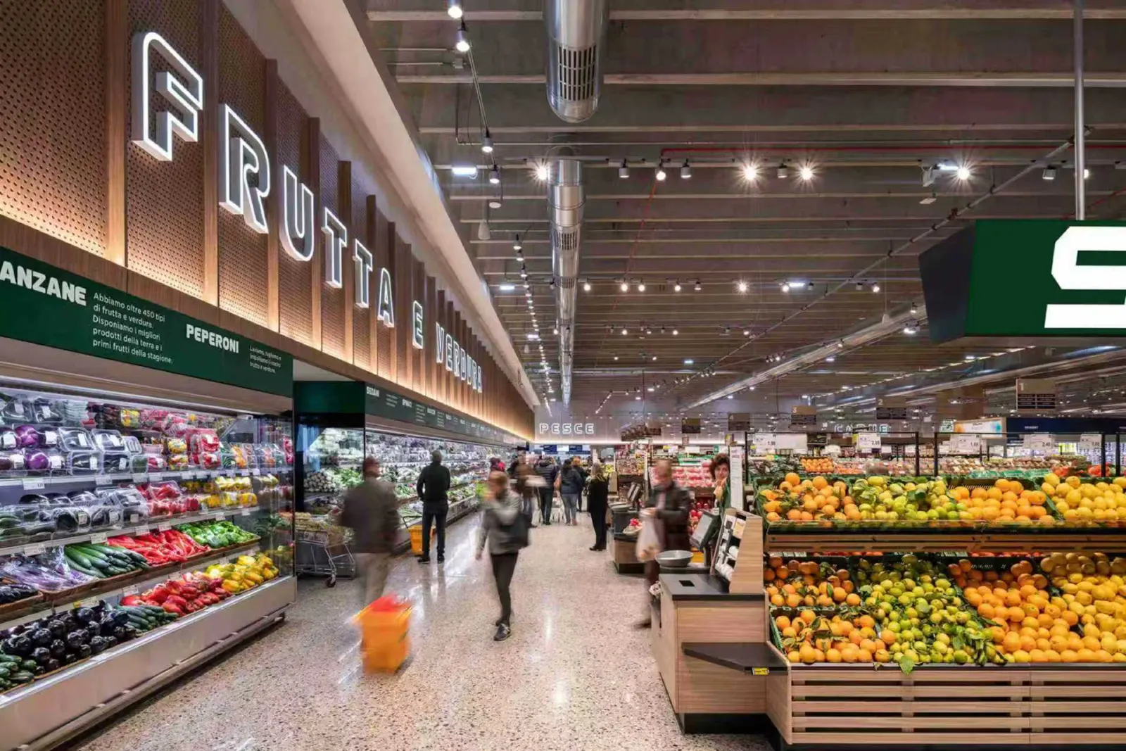 A spacious market interior with high ceilings, produce displays, and wide aisles, conveying the character of the on-site supermarket.